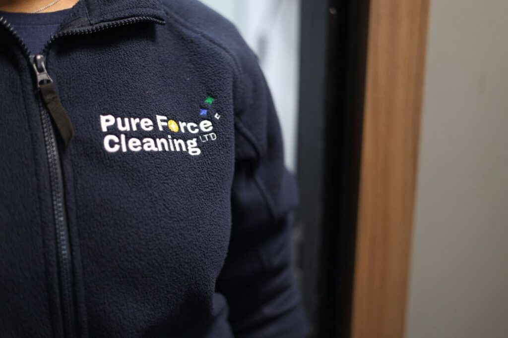 A Photo of an employee of Pure Force Cleaning wearing a branded jumper with their brand design