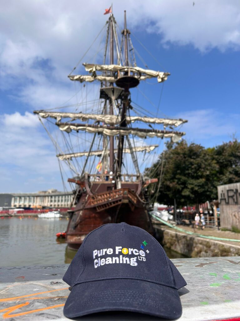 A photo at Bristol Harbour showing the branded hat of Pure Force Cleaning with their Brand Design