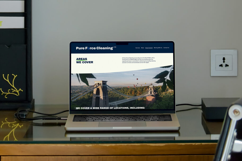 A desk view showing a laptop displaying Pure Force Cleaning Website design and their Brand Design